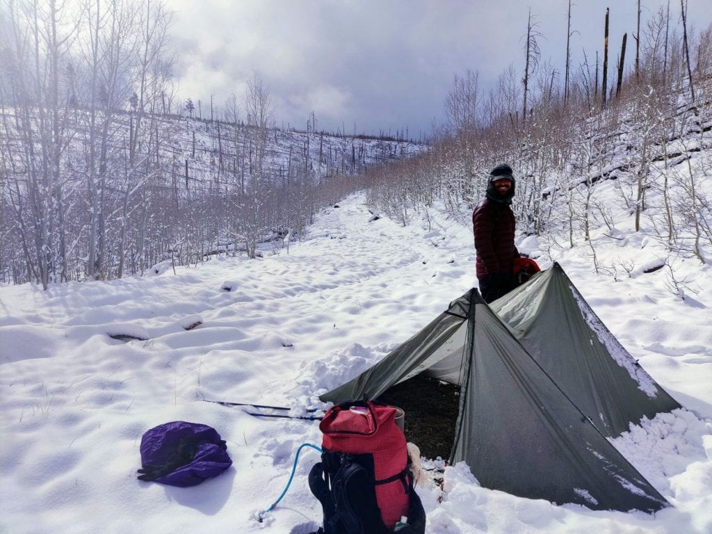 Tarp and backpackers next to snow-covered Arizona Trail