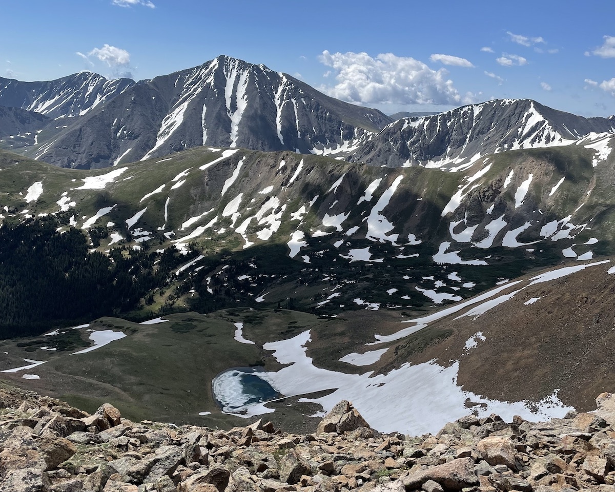 View of Torreys Peak from the summit of Mt Snitkau with a blue alpine lake below