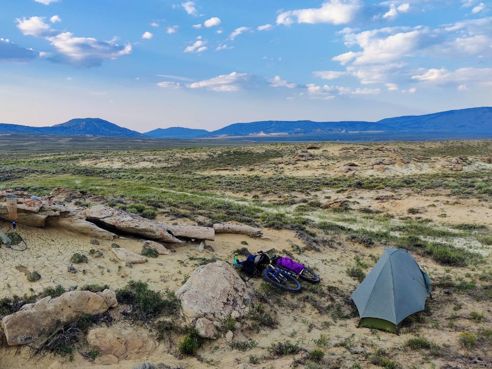 Bike next to tent in wide open basin in Wyoming
