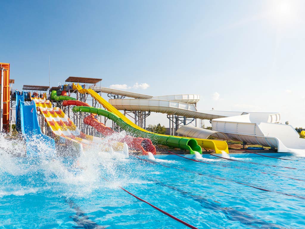 A photo featuring a pool and colorful slides in a water park, representing one of the most fun activities for kids in Destin