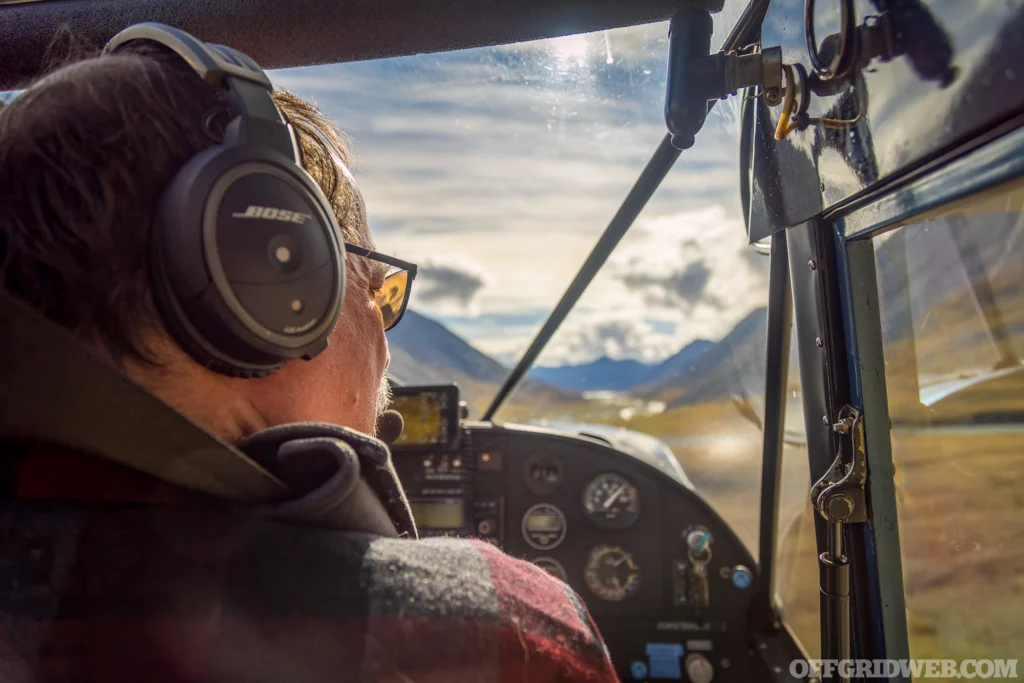 Photo of a man in the cockpit of a bush plane.