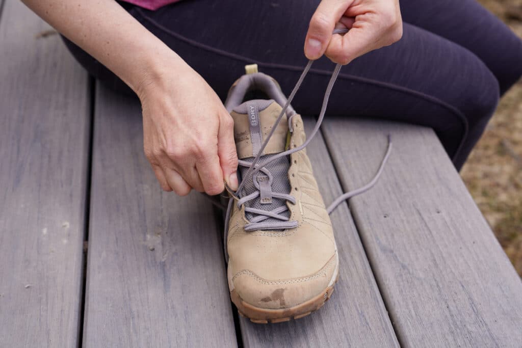 woman pulling laces out of shoes