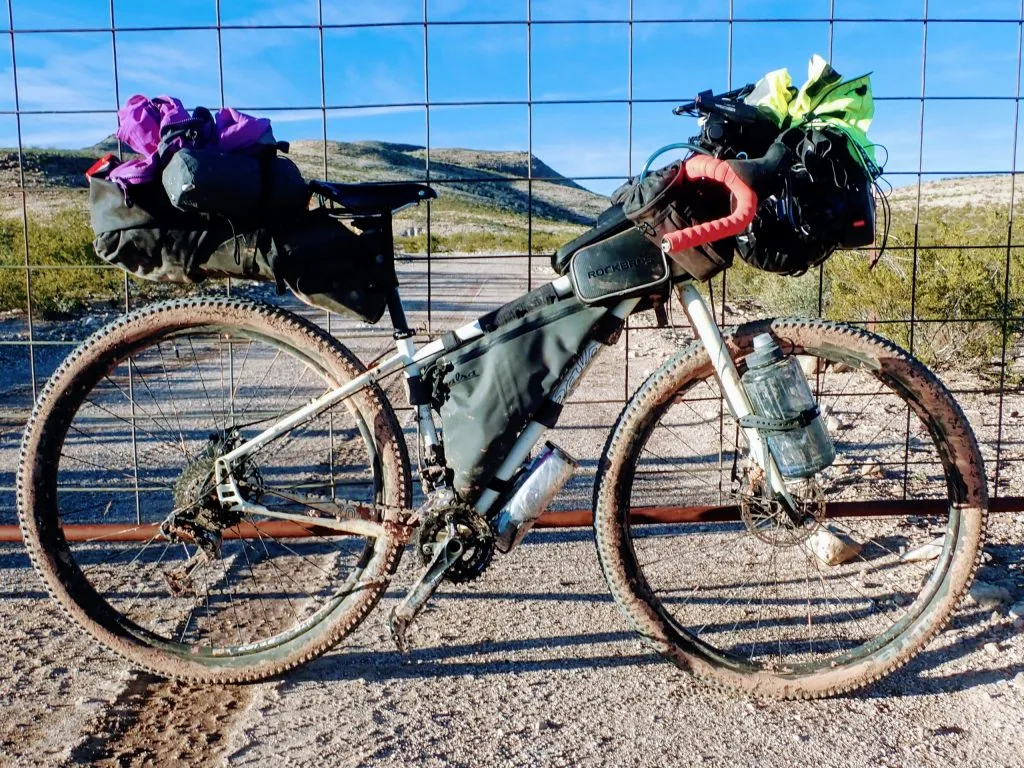 Loaded bikepacking bike in front of gate