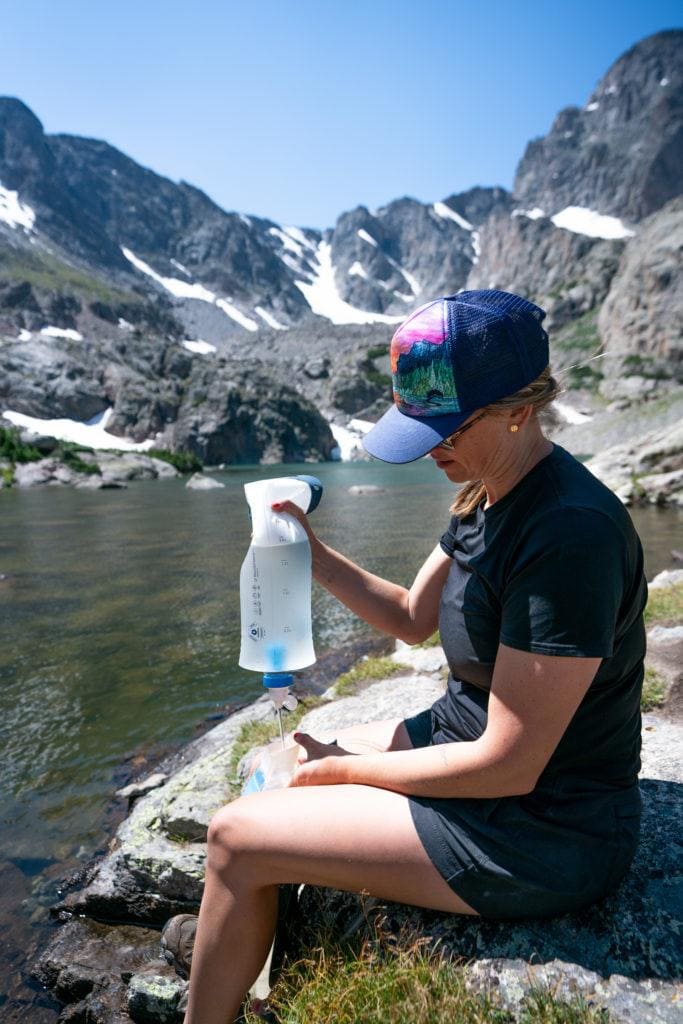 Kristen Bor filtering water from a mountain lake in Rocky Mountain National Park