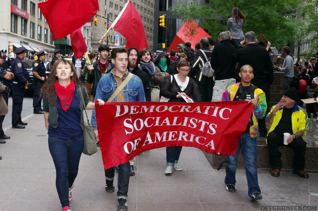 Photo of a group claiming to be Democratic Socialists of America carrying their banner in a protest march.