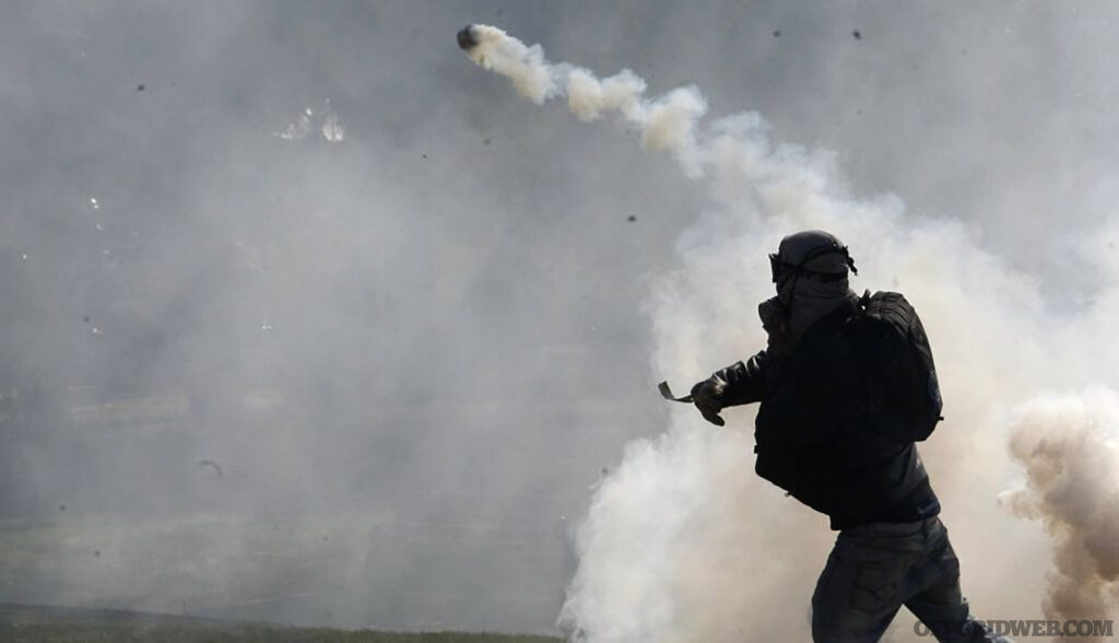 A student protester throws a tear gas canister towards riot policemen during a demonstration against the government to demand changes in the public state education system in Santiago, August 8, 2012. Chilean students have been protesting against what they say is profiteering in the state education system. REUTERS/Eliseo Fernandez (CHILE - Tags: POLITICS CIVIL UNREST EDUCATION)