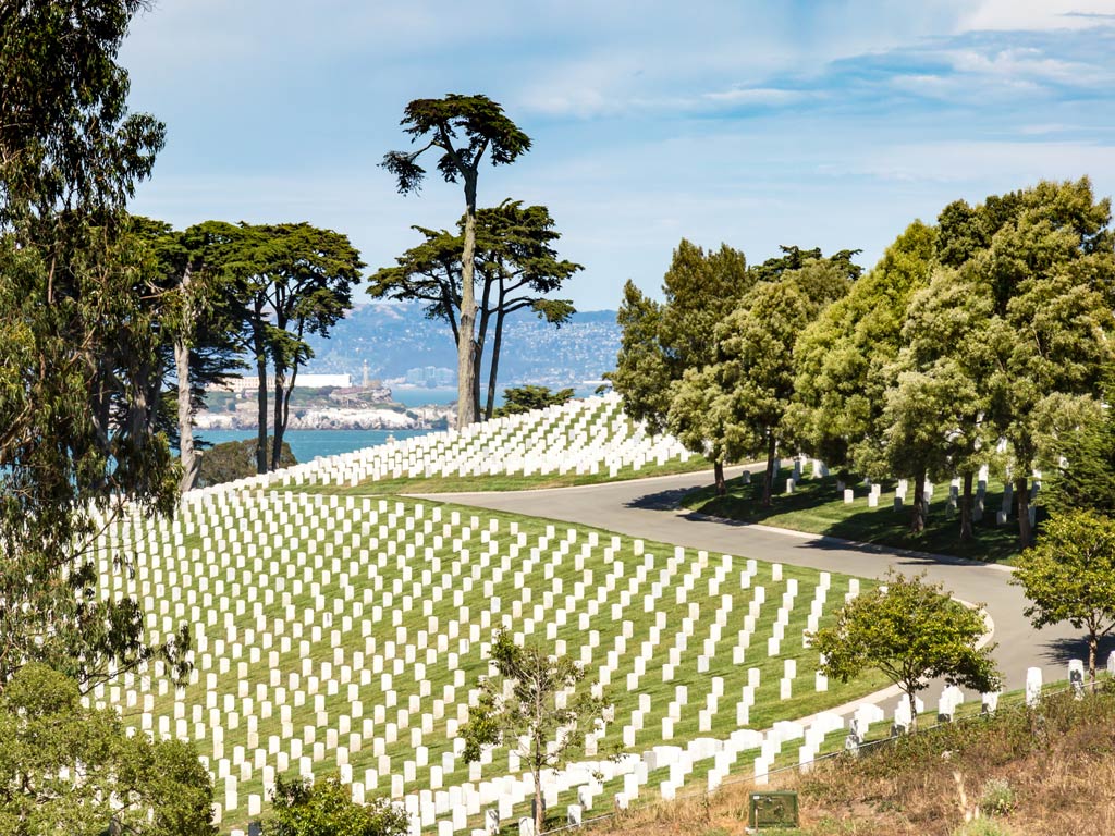 A photo featuring the National Cemetery in Presidio in San Francisco with a view of the water in the distance