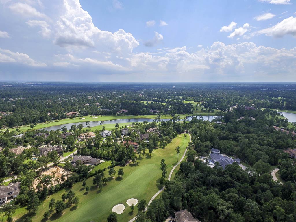 An aerial view of the lush forests, greenery, and water in the community of The Woodlands in Texas on a lovely spring day