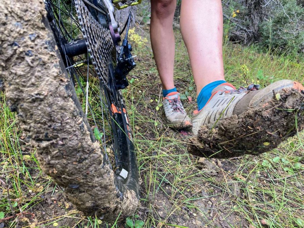 very muddy bike tire and bottom of cycling shoe