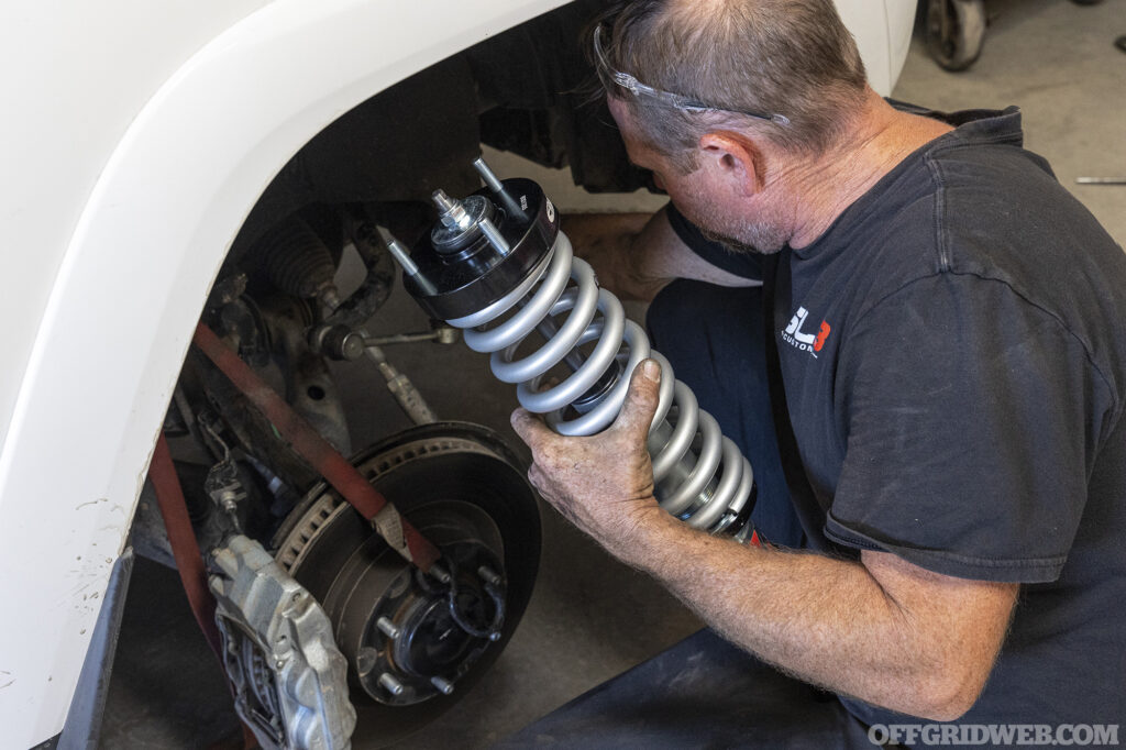 A mechanic working on the suspension of a toyota 4runner.