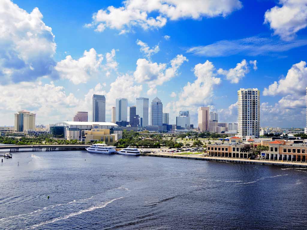 The cityscape of Tampa, Florida, taken from the Tampa Bay, with waters visible in the foreground while the city's coastline and high-rise buildings make up the rest of the photo.