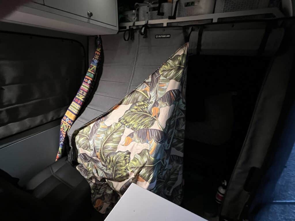 Baby travel crib set up with black out curtains in a Sprinter Van