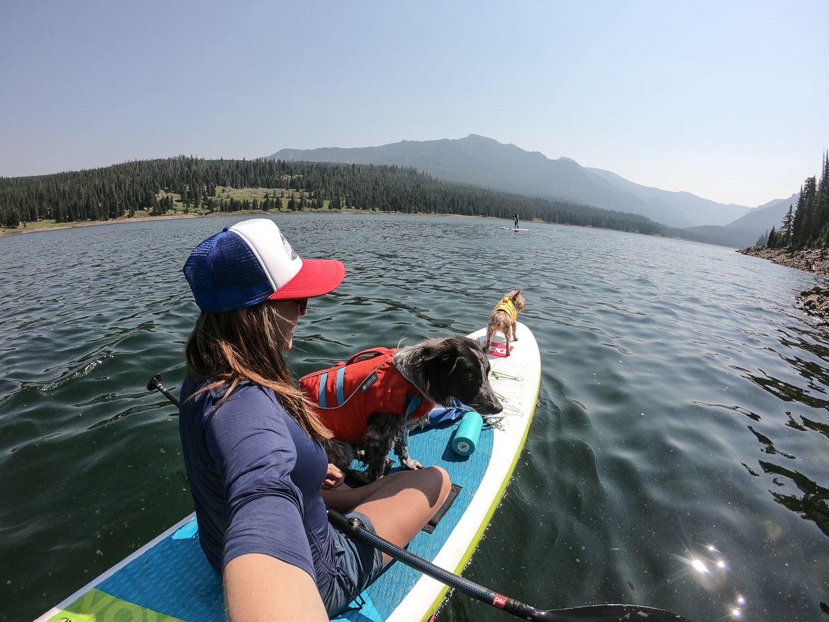 Kristen Bor on a paddle board with a dog wearing the Ruffwear Float Coat Dog Life Jacket