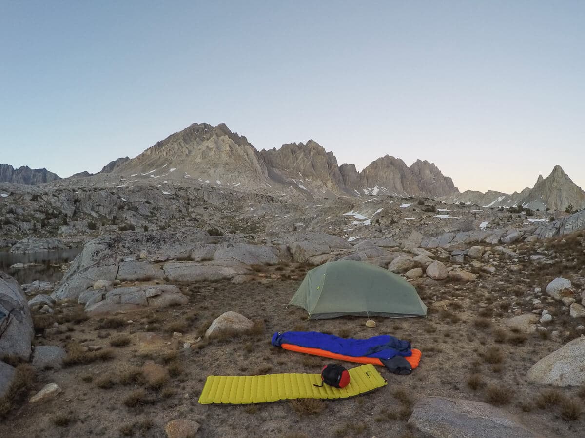 Tent, sleeping bag, and sleeping pad laid out on ground on backpacking trip to Dusy Basin