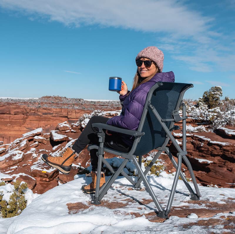 Kristen Bor sitting on a YETI Trailhead Camp Chair in a scenic Utah desert location with snow on the ground