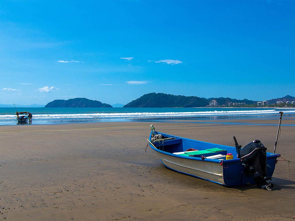 A view of a lone small wooden boat on the beach near Los Sueños, Costa Rica, on a clear day