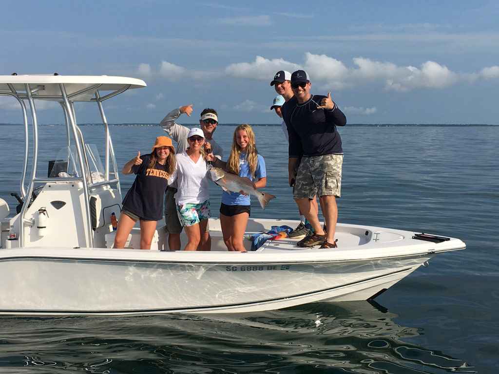 A photo featuring a captain posing with clients on a charter boat during a wonderful fishing trip in South Carolina 
