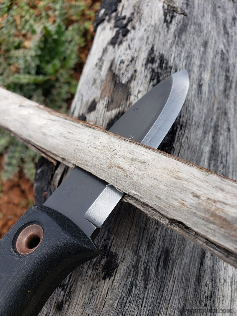 A knife splitting a small piece of dry wood.