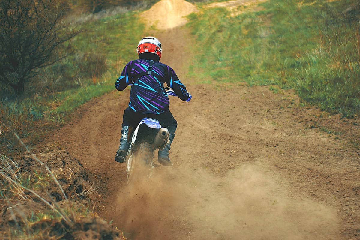 Motorcyclist navigates a dirt trail.
