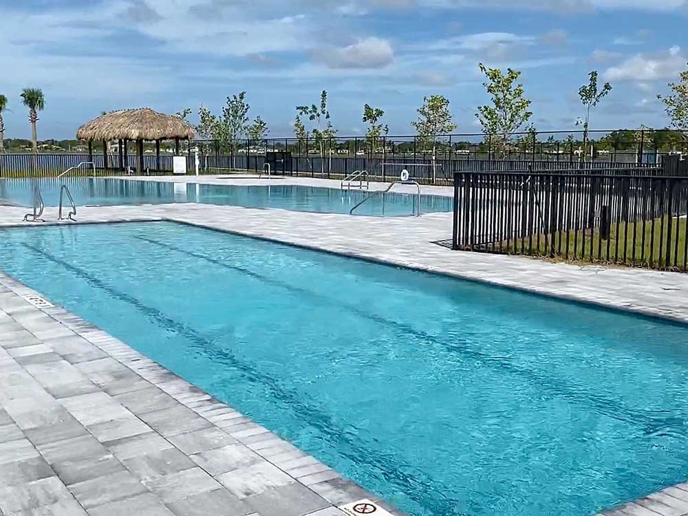 Rectangular pools with tiki hut in background.